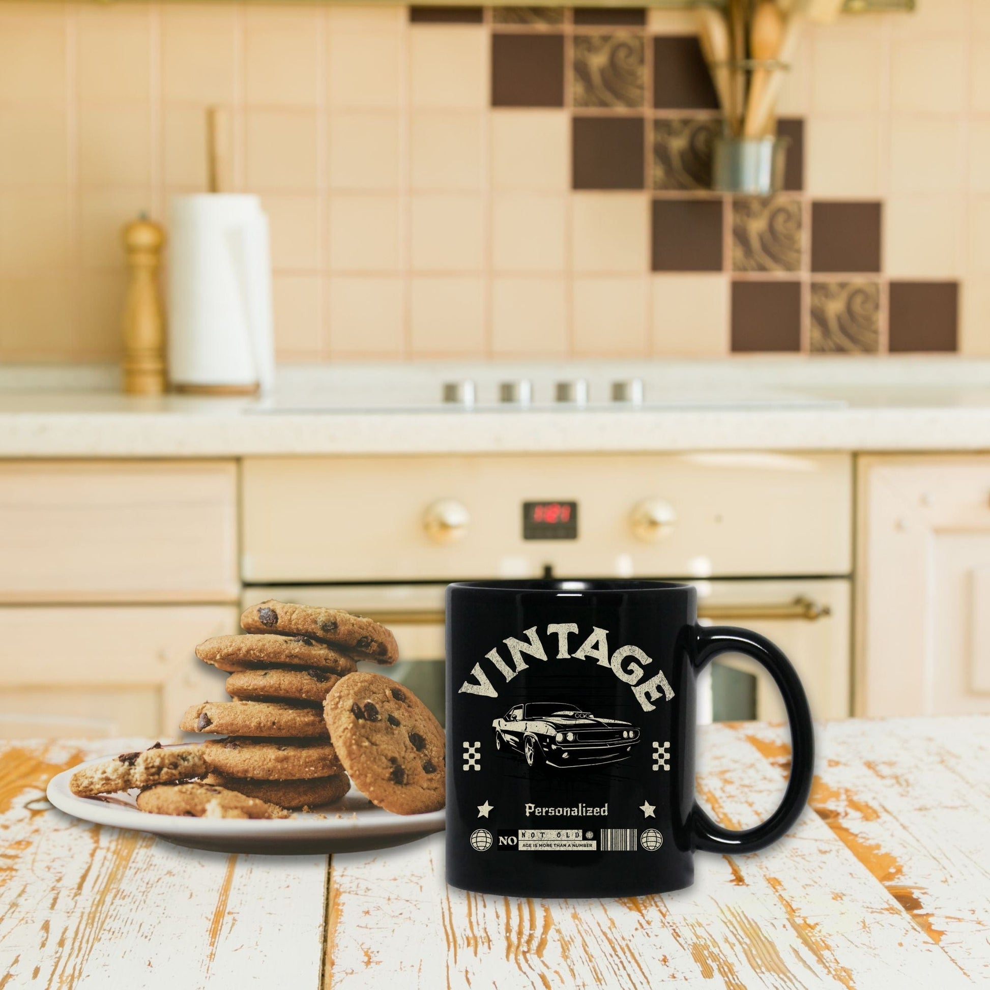 a black coffee mug sitting next to a plate of cookies