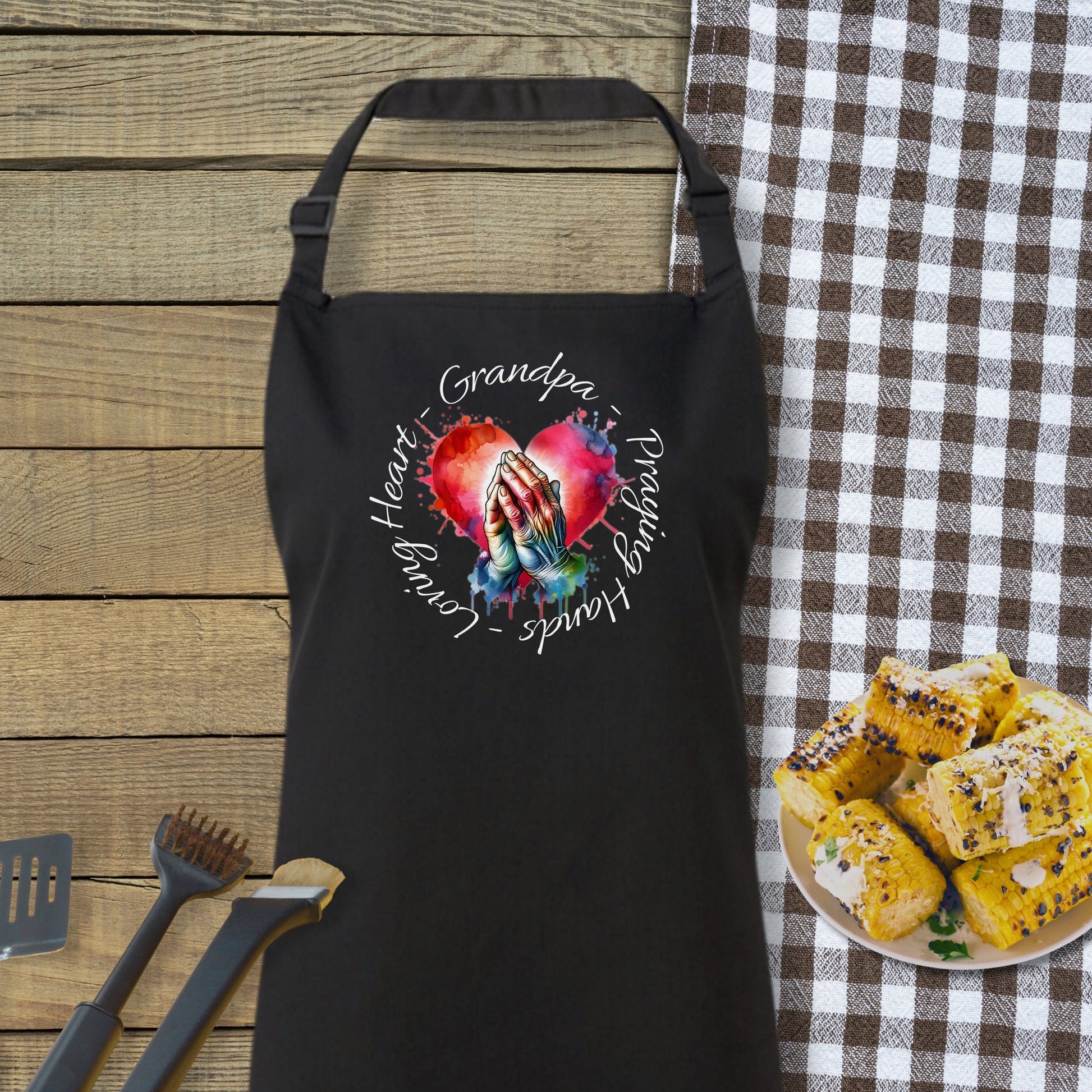 a black apron and a plate of food on a table