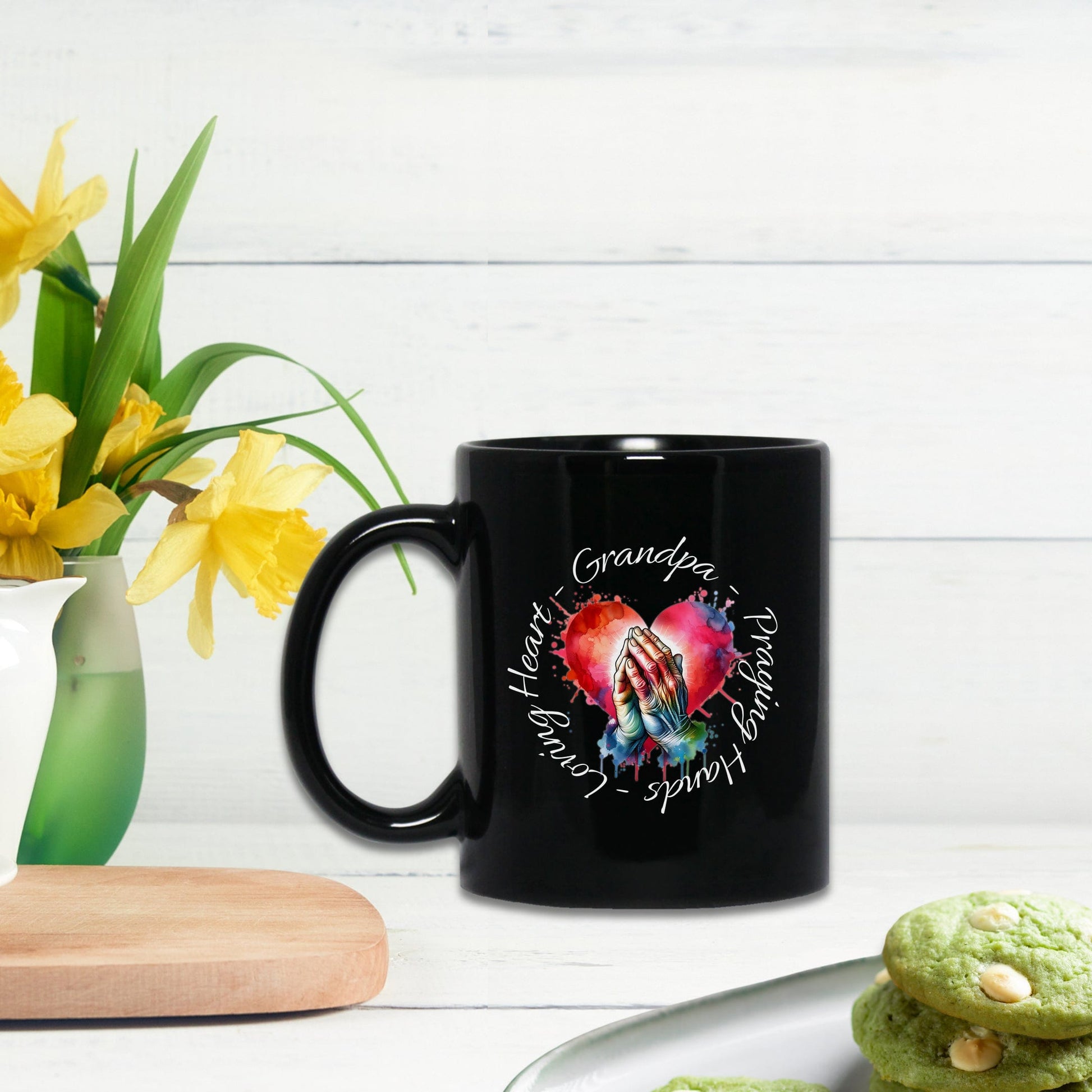 a black coffee mug sitting next to a plate of cookies