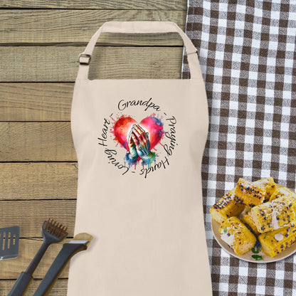 a white apron with a picture of a hand holding a heart on it next to