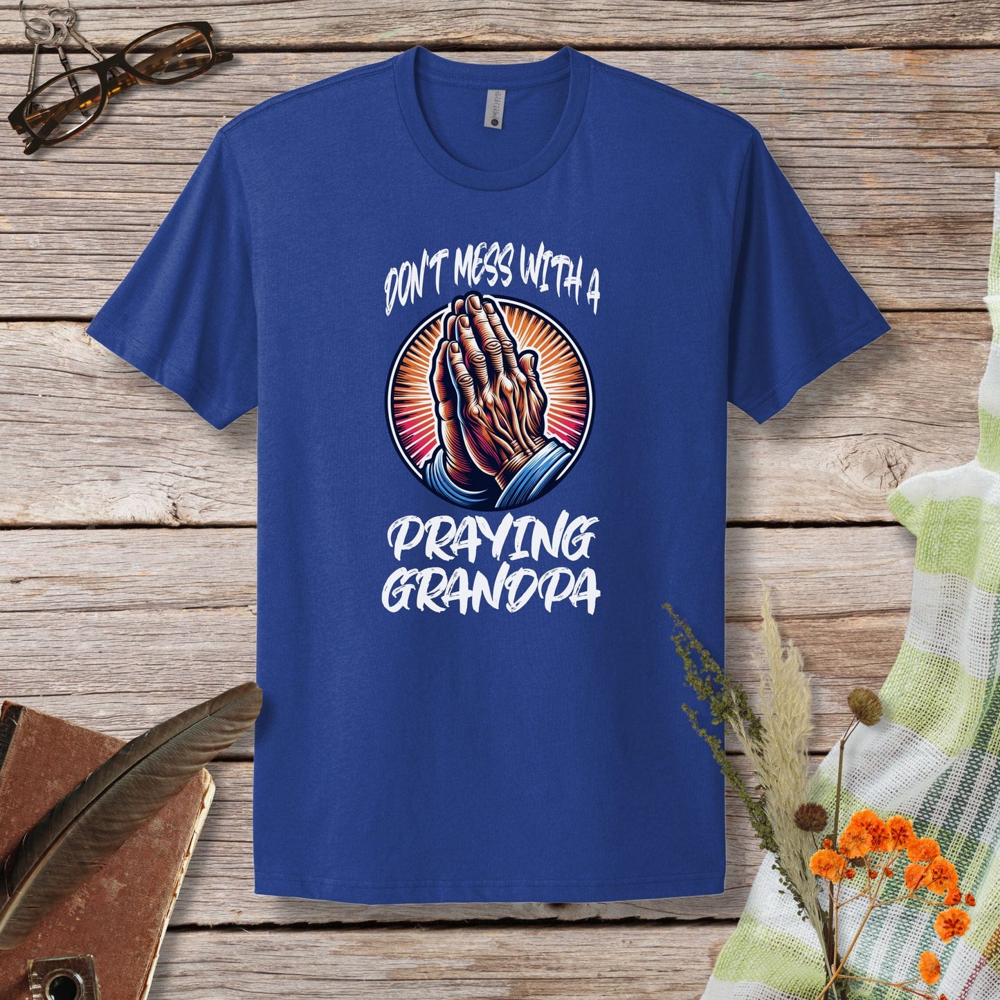 a blue t - shirt that says don't mess with a praying grandpa