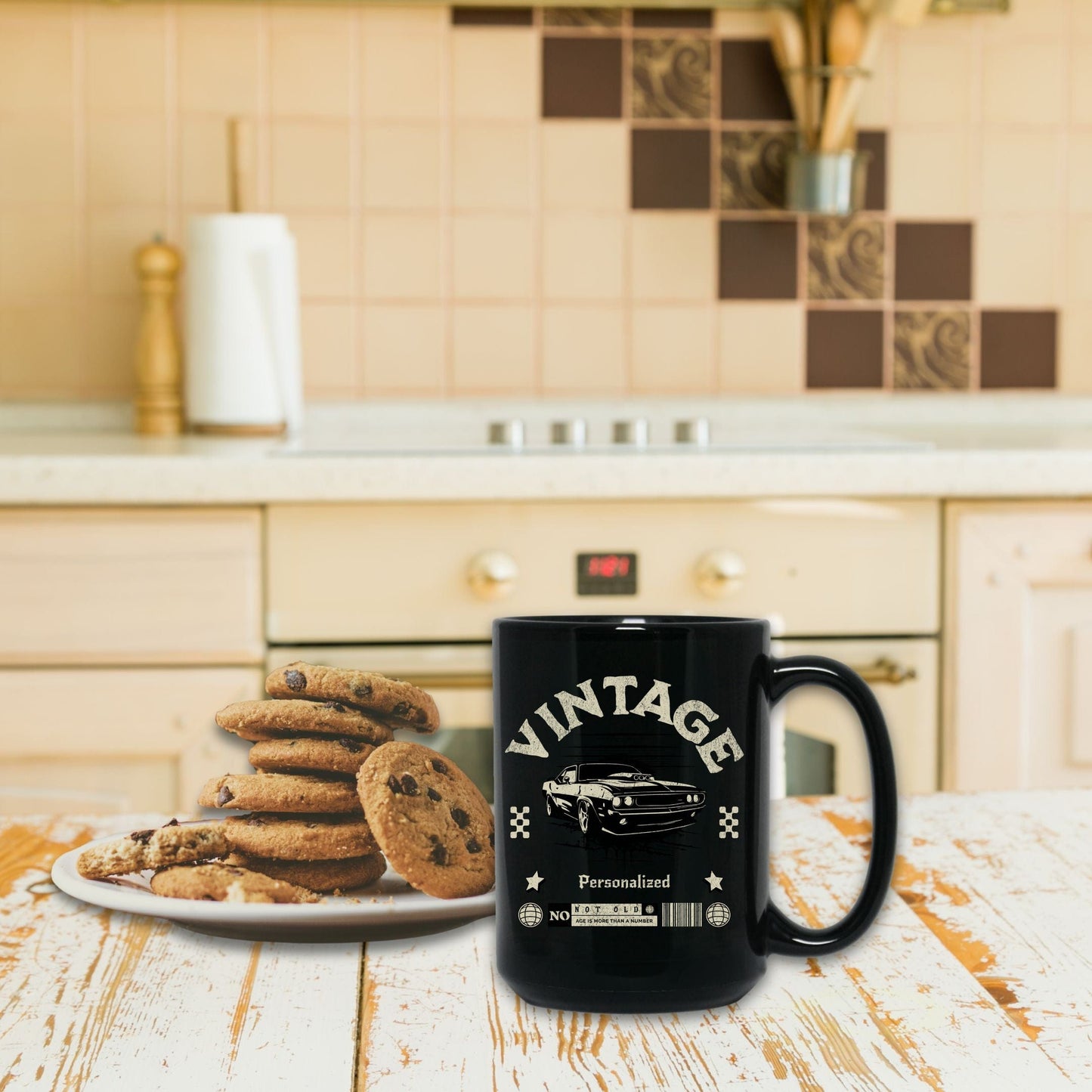 a black coffee mug sitting next to a plate of cookies