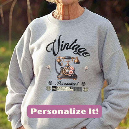 an older woman wearing a sweatshirt with a phone on it