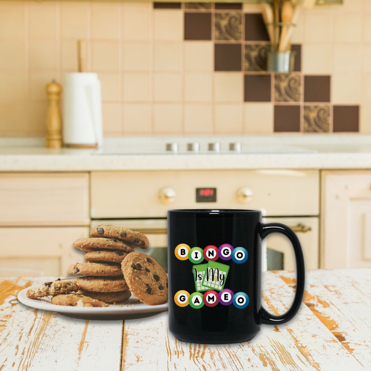 a black coffee mug sitting next to a plate of cookies