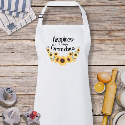 a white apron that says happiness is being grandma