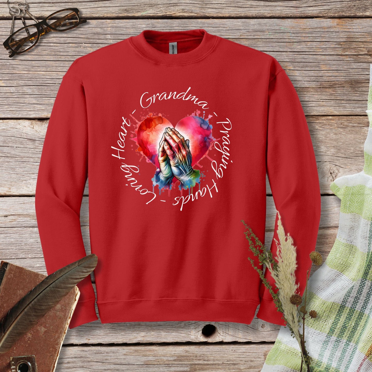 a red sweatshirt with a picture of a hand holding a heart