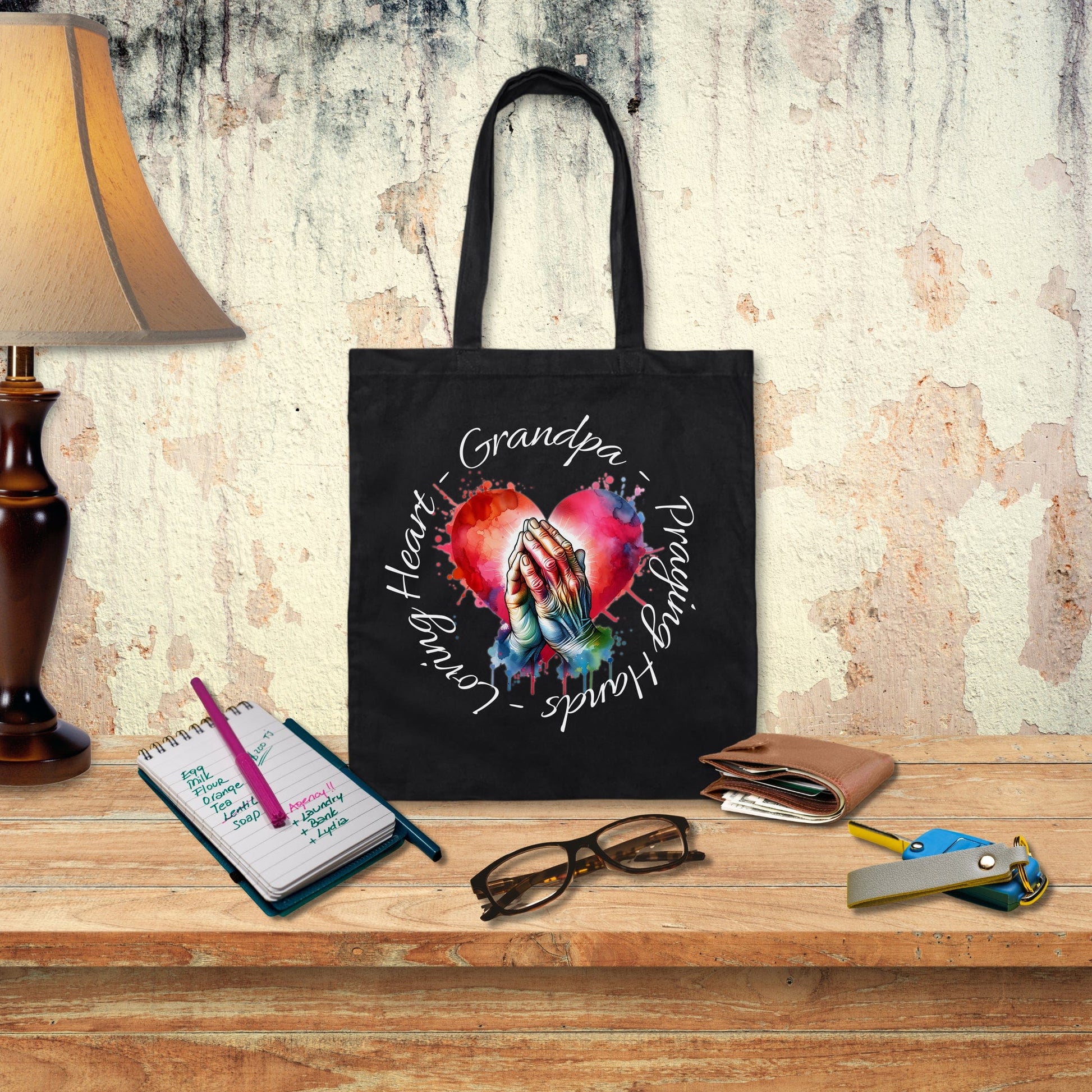 a black tote bag with a picture of a hand holding a heart