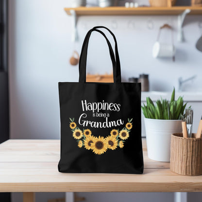 a black tote bag with sunflowers and the words happiness is being grandma