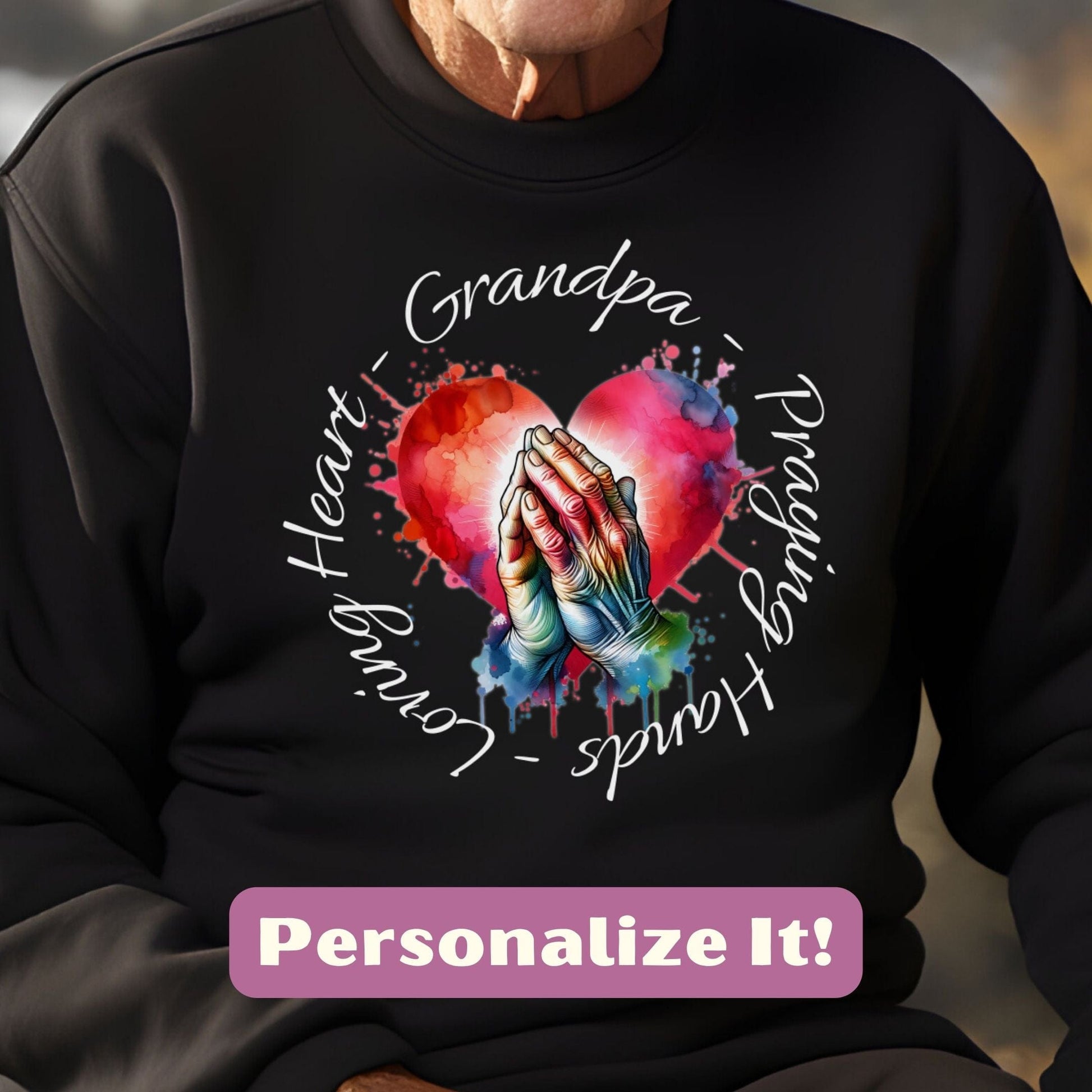 a man wearing a black sweatshirt with a heart and hands on it